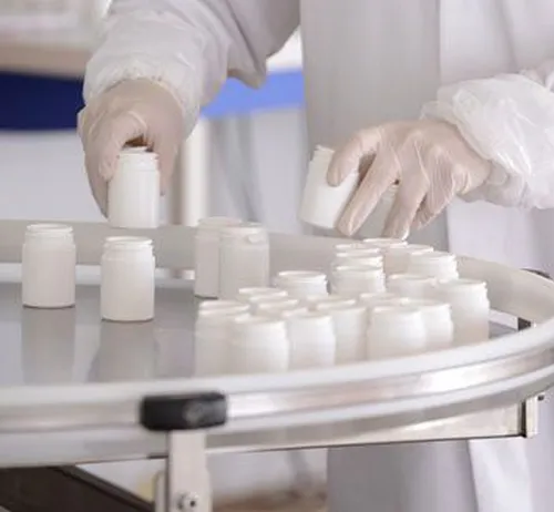 Reportage photo industriel a Lyon montrant un technicien manipulant des produits pharmaceutiques en salle blanche