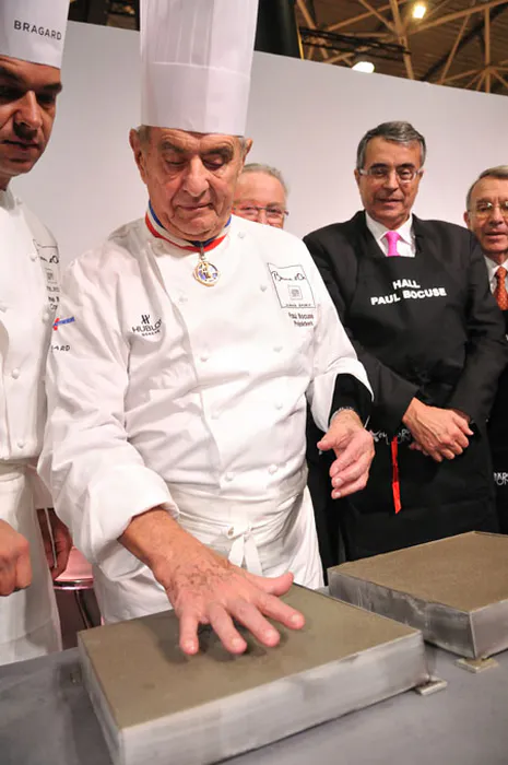 Paul Bocuse apposant son empreinte de main lors de l’inauguration du Hall Paul Bocuse à Eurexpo Lyon, reportage photo événementiel