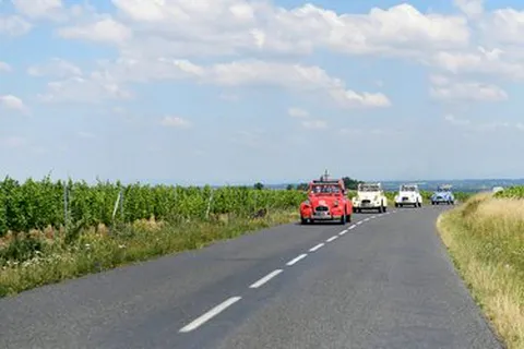 Photo de plusieurs 2cv sur une route de campagne du Beaujolais lors d'un séminaire d'entreprise