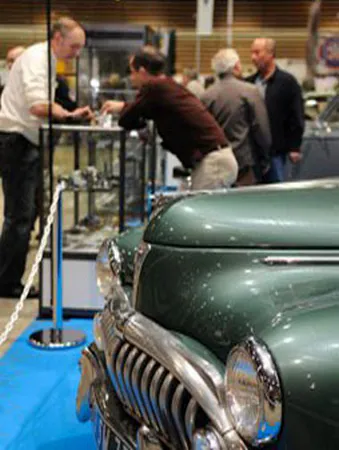 Échanges entre visiteurs et exposants devant une voiture ancienne au salon Epoqu'Auto à Eurexpo Lyon