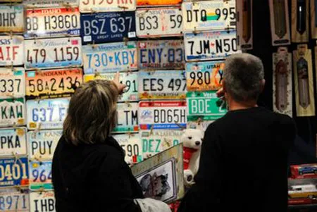 Plaques d'immatriculation anciennes présentées par un exposant au salon Epoqu'Auto