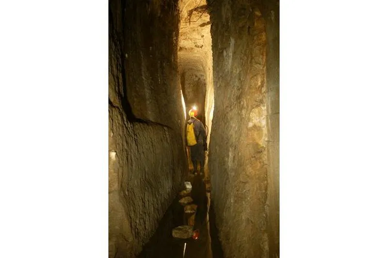 Lyon Souterrain la passe du chien fou mont du lyonnais explorateur en tenue de speleologue credit photo Philippe Théry Photographe
