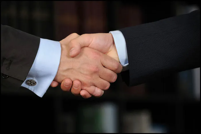 Détail d'une poignée de main entre professionnels, symbole de partenariat et de confiance en entreprise