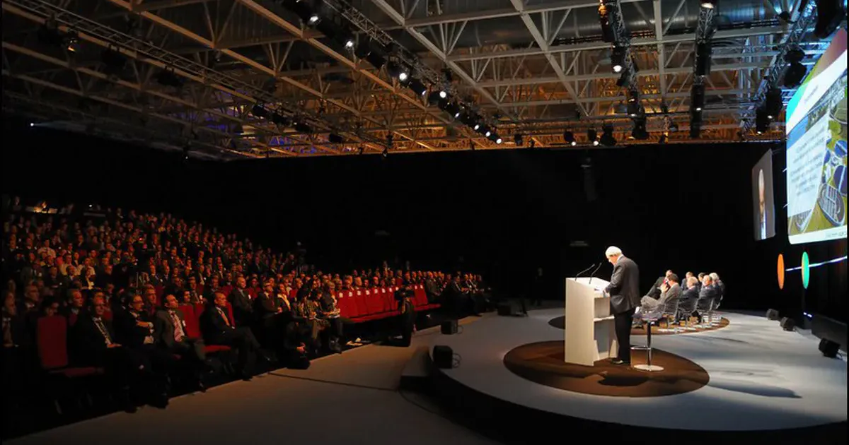 Conférence professionnelle à Eurexpo Lyon, orateur de trois-quarts dos face à une salle comble lors d’un événement d’entreprise