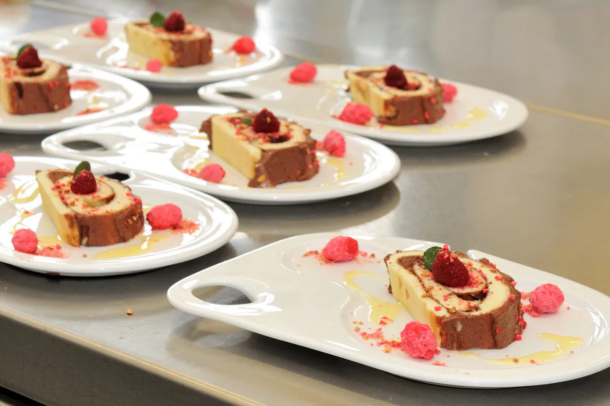 Équipe intergénérationnelle présentant fièrement sa pâtisserie devant le jury