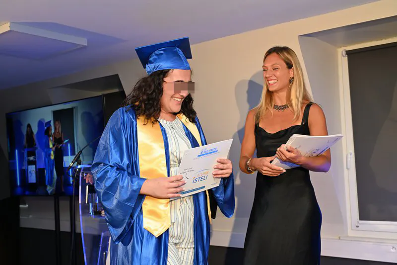 Diplômée ISTELI Lyon tenant son parchemin et souriant lors de la cérémonie de remise de diplôme
