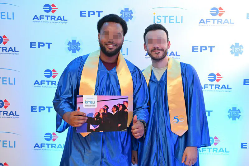 Portrait de deux diplômés ISTELI Lyon en toge devant le mur de logos partenaires
