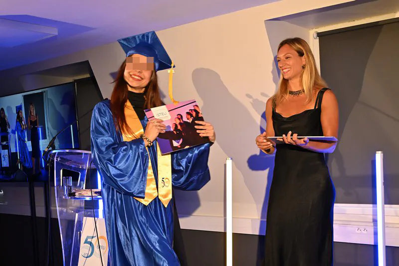 Diplômée ISTELI recevant son parchemin sur scène avec sourire lors de la remise de diplôme Lyon