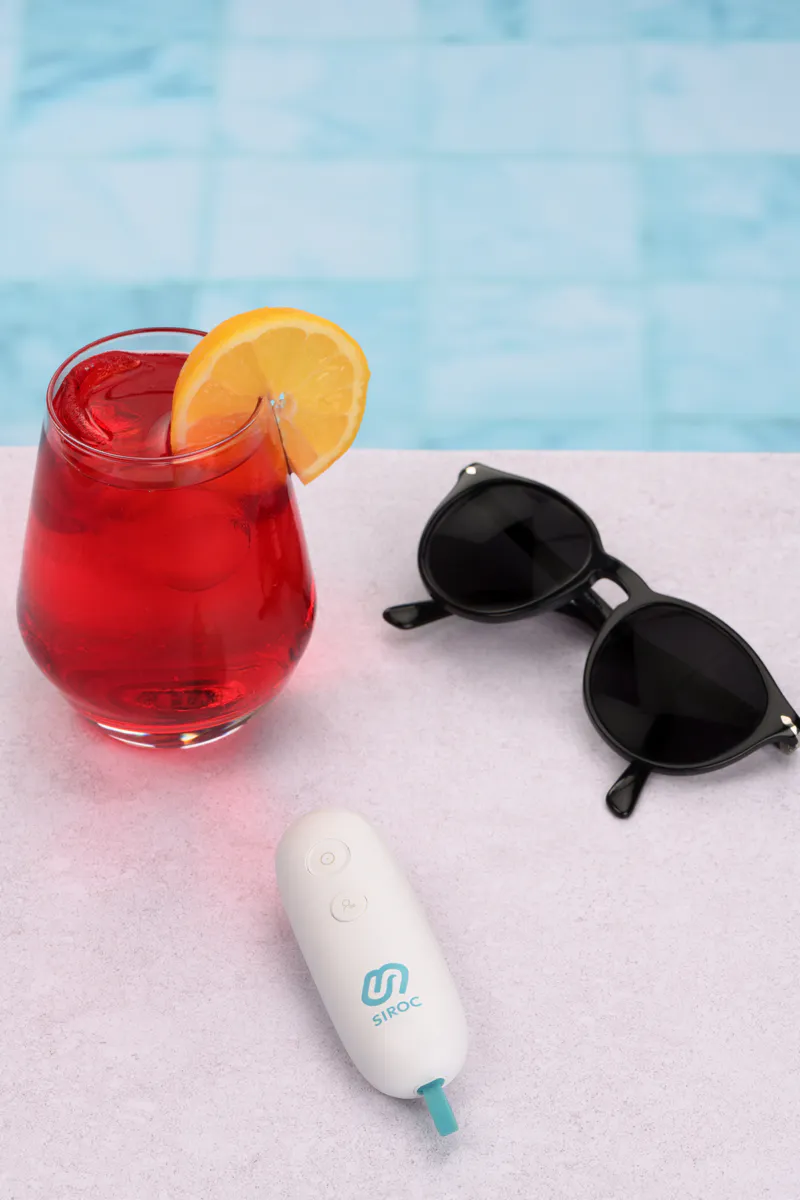 Appareil apaisant piqûre d'insecte posé au bord d'une piscine – photo lifestyle e-commerce