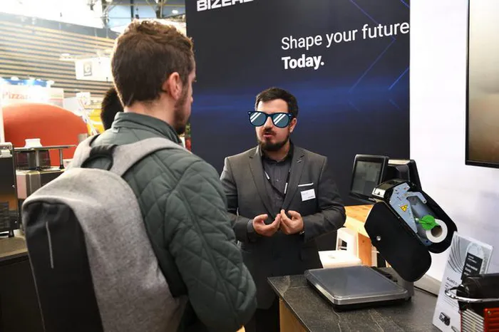 Echange professionnel entre un exposant Bizerba et un visiteur au salon Sirha