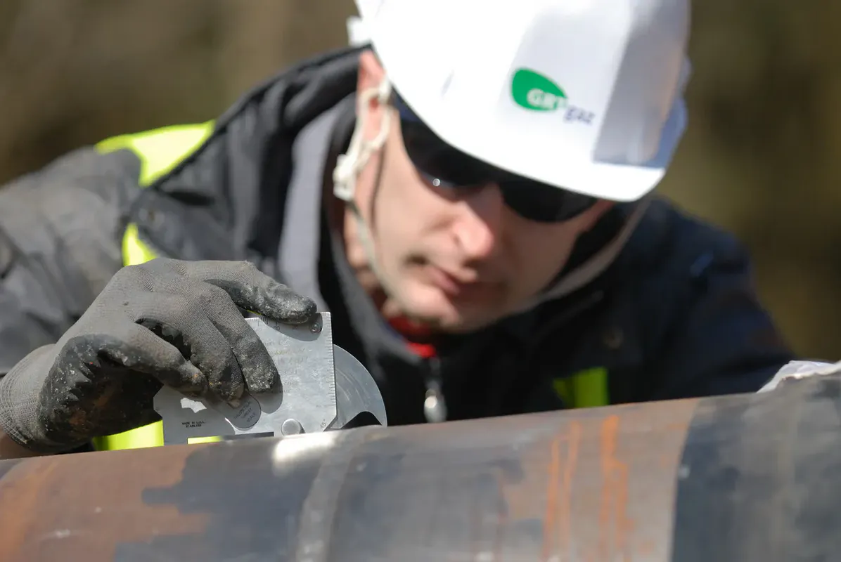 Technicien GRTgaz contrôlant une soudure avec jauge de mesure – contrôle qualité chantier gazoduc Mâconnais