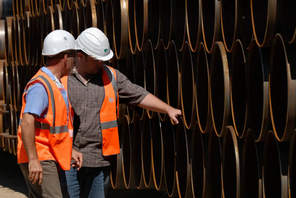 Responsables GRTgaz inspectant le revêtement anti-corrosion des conduites acier stockées avant pose – chantier gazoduc