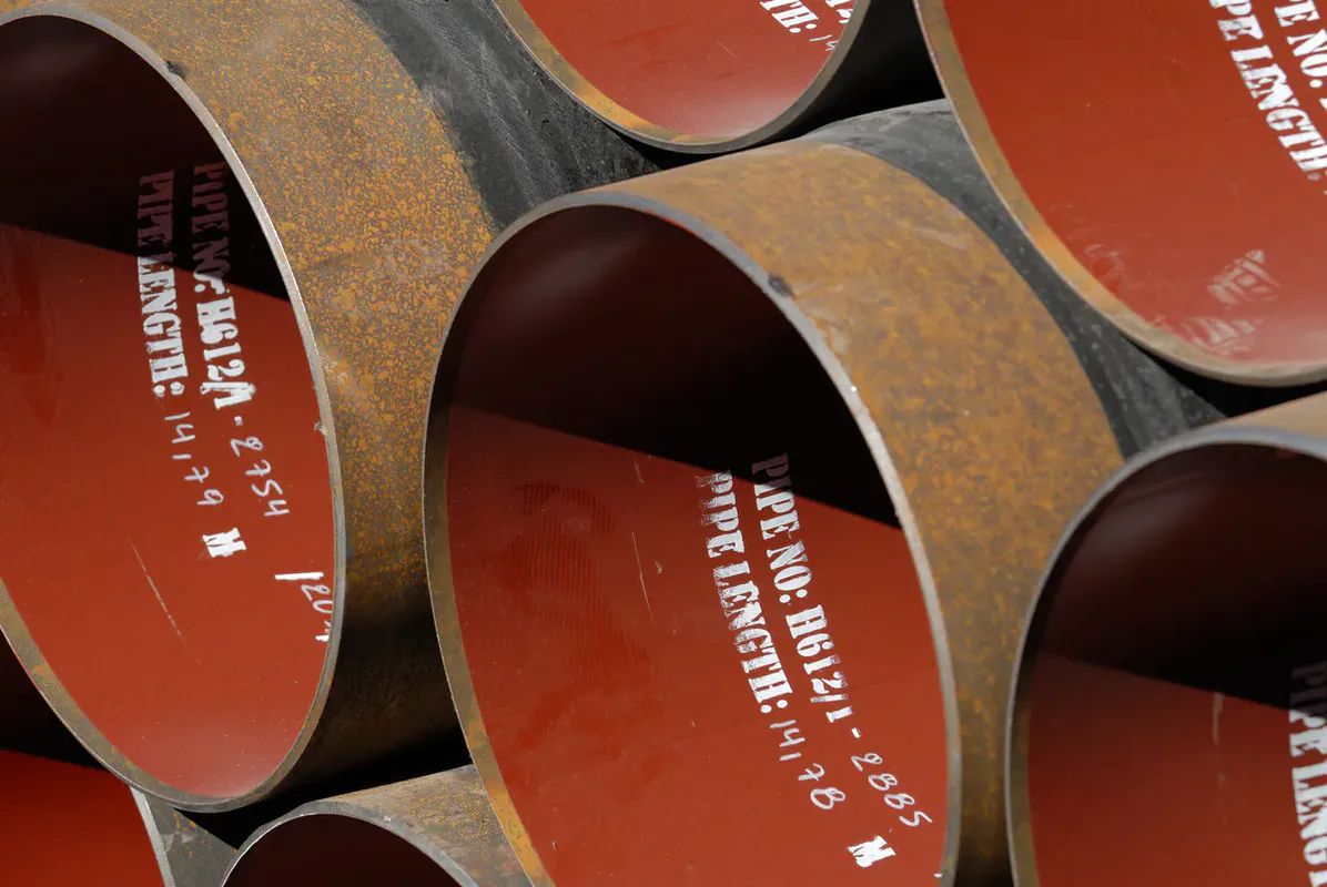 Sections de conduites acier DN600 avec marquages de référence et protection anti-corrosion rouge – chantier GRTgaz