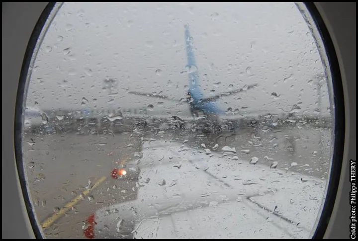 Pluie sur le hublot d'un avion à l'aéroport de Paris