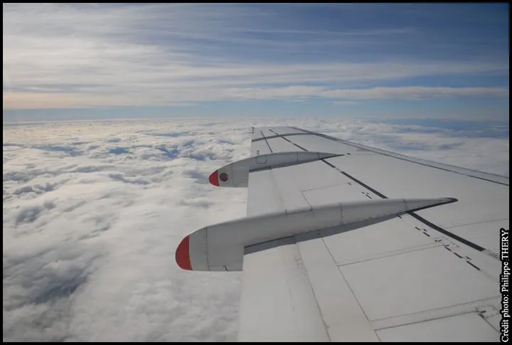 Réacteur et aile d'avion au-dessus d'une mer de nuages, vol Paris Martinique
